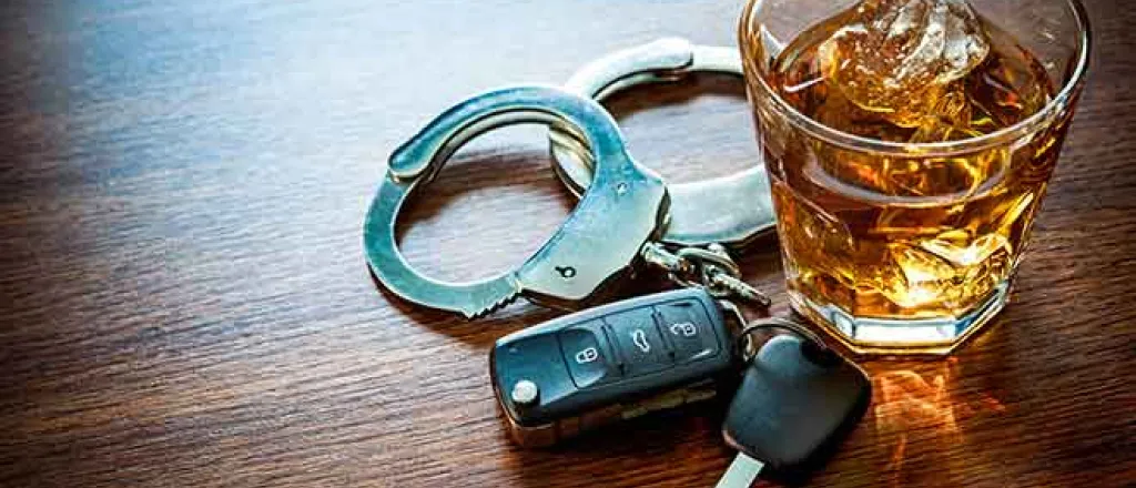 Handcuffs, car keys and an alcoholic drink