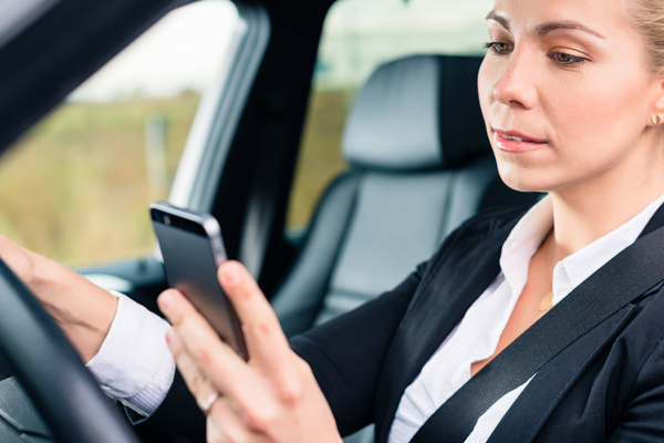 Woman looking at phone while driving