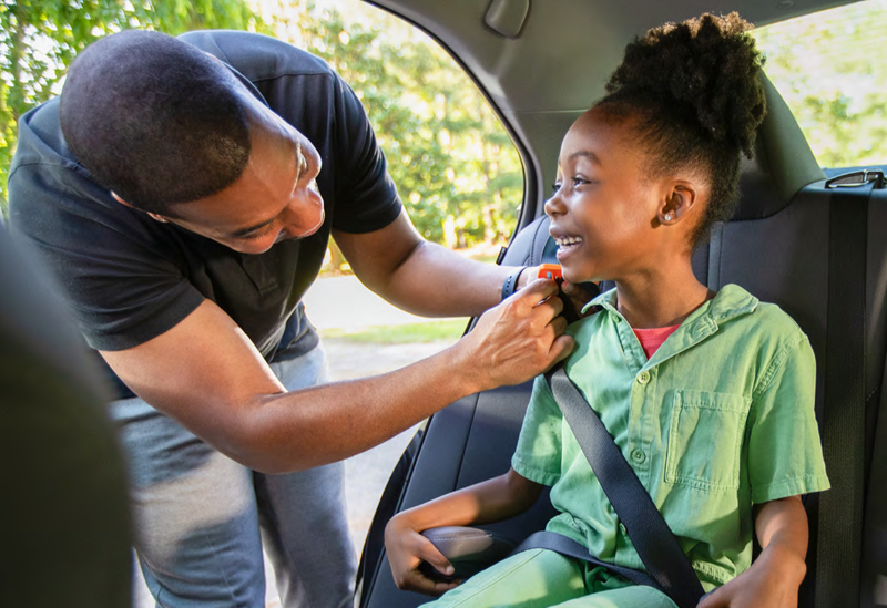 Child being buckled into a car seat