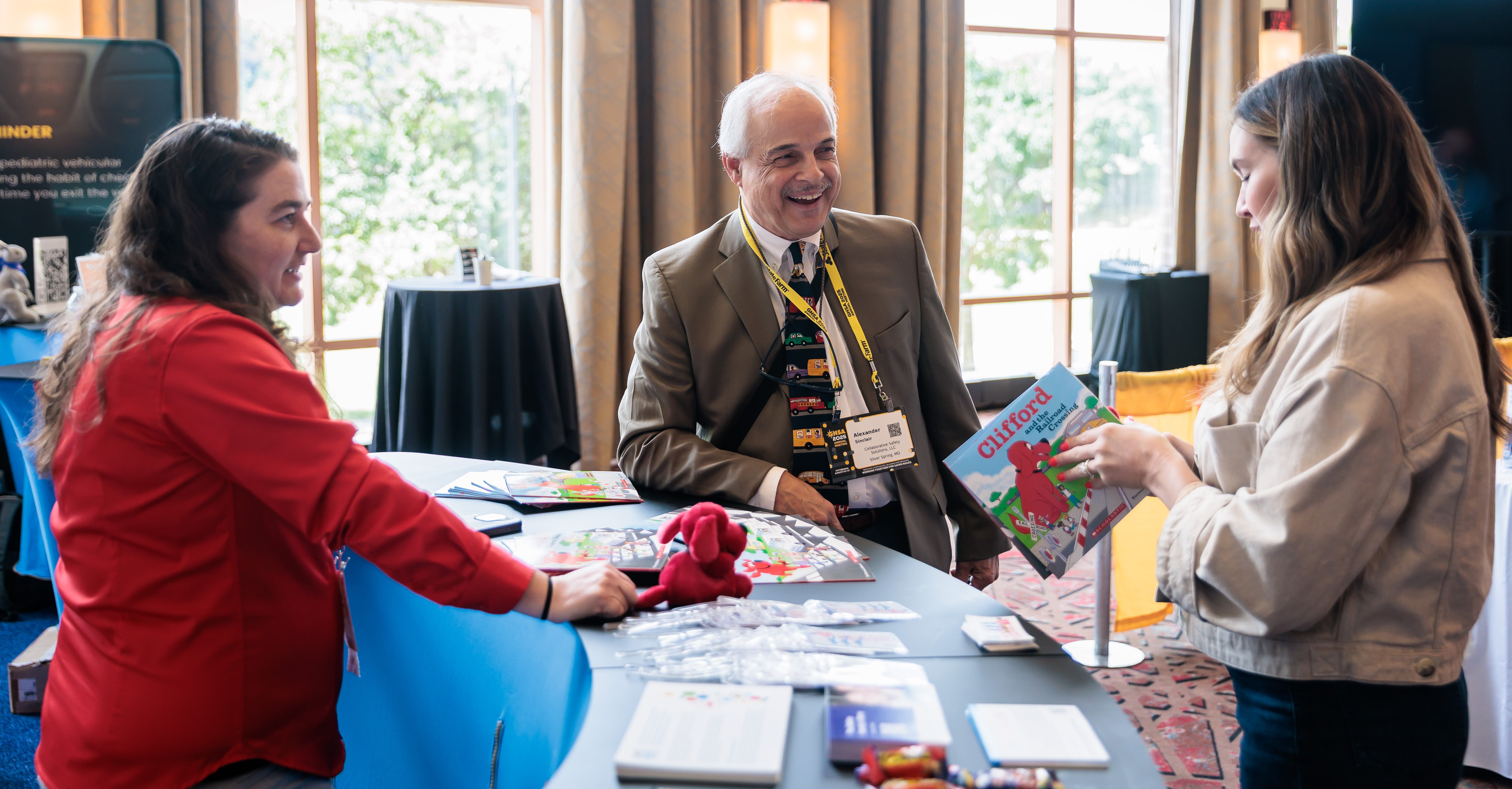 Three people standing around a table and smiling