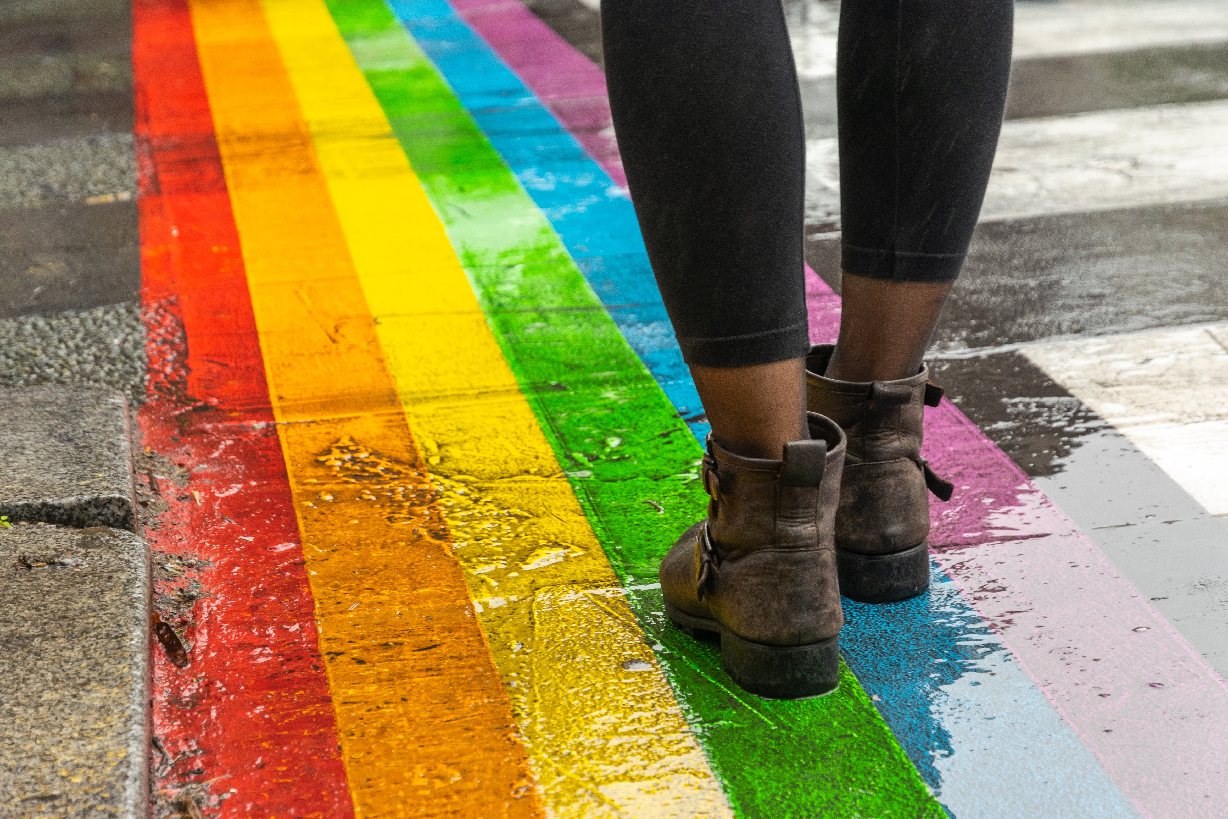 Person walking on rainbow crosswalk