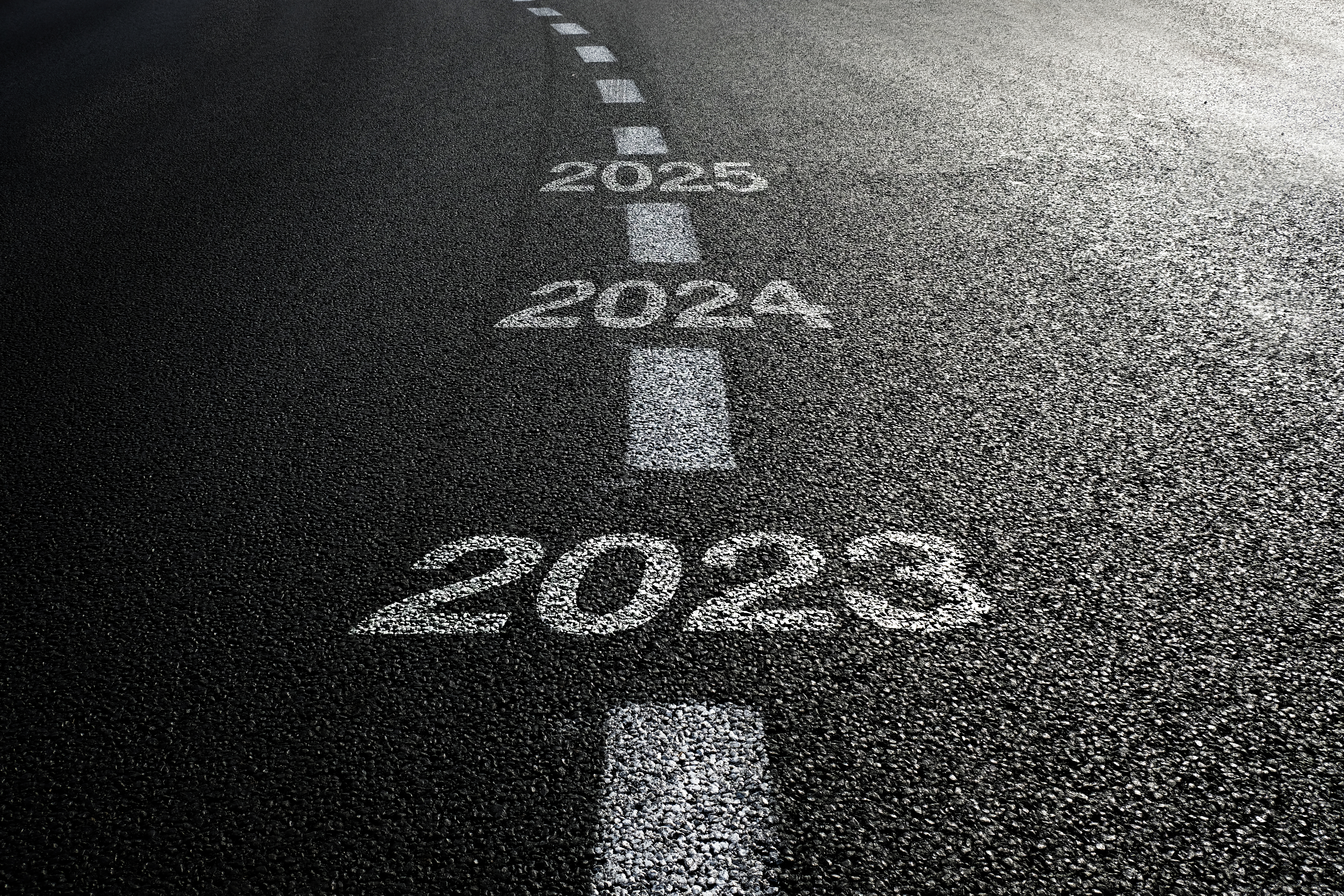 An image of a road with the years 2023, 2024 and 2025 written on the road