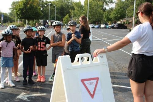 Kids wearing helmets receiving bike-riding instructions