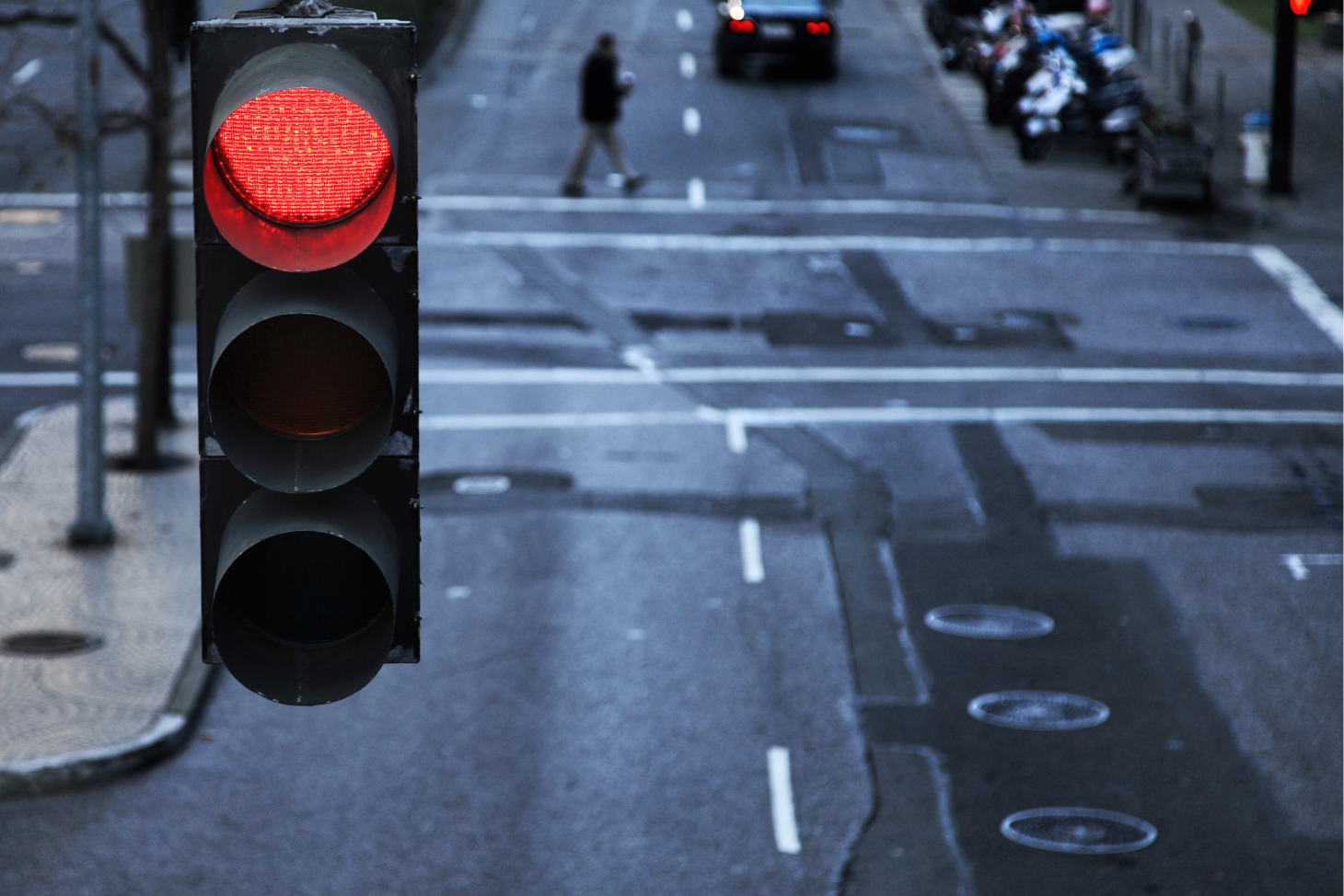 Image of a red light with a crosswalk in the background