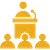 Icon of a person behind a podium with an audience listening