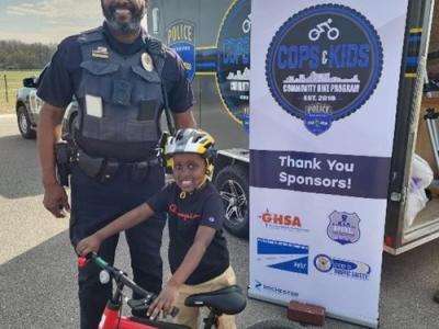 Image of a police officer and a small child with a bike